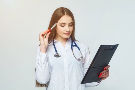 portrait of a doctor with clipboard and stethoscope isolated on a white backgroundの写真素材