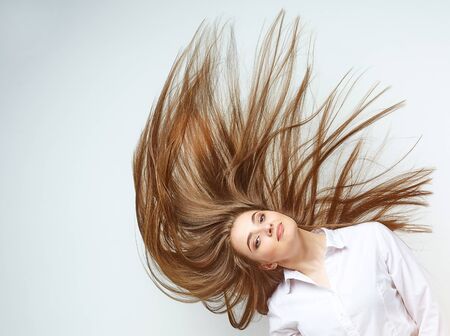beautiful girl with very long hair on a white backgroundの写真素材