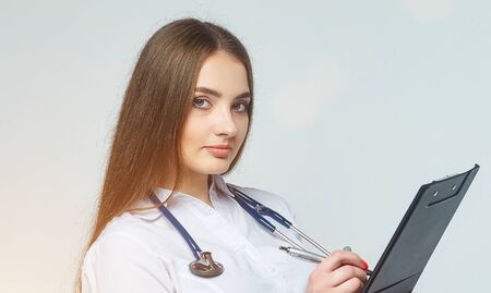 portrait of a doctor with clipboard and stethoscope isolated on a white backgroundの写真素材