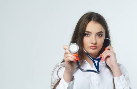 Portrait of a young woman doctor with a stethoscope on a white backgroundの写真素材