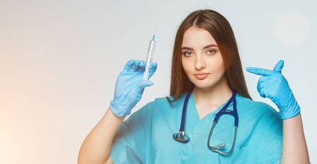 the female doctor points her finger at the syringeの写真素材