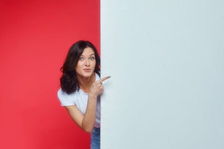 beautiful girl gestures to an empty space for the text. Presentation of your product. the concept of advertisingの写真素材