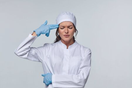 Medical concept of a female doctor in a white coat with a stethoscope, doctor. A female hospital worker looks at the camera and smiles, Studio, White backgroundの写真素材