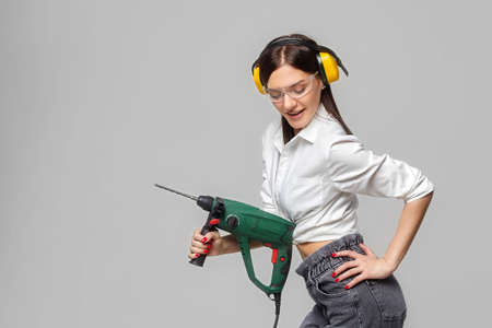 sexy Builder girl holding a drill. concept of advertising Housewives, work tools and construction-related works ...の写真素材