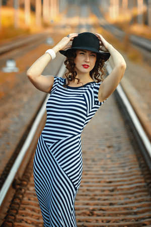 attractive girl in a striped dress posing in the summer in the fieldの写真素材