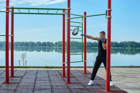 athletic man, in the morning in the city Park doing exercises with gymnastic ropesの写真素材