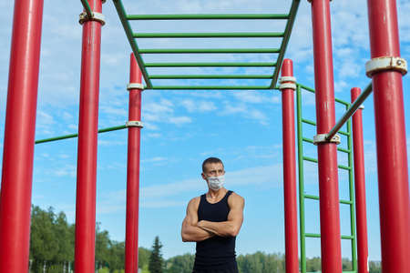 athletic man, in the morning in the city Park doing exercises with gymnastic ropes