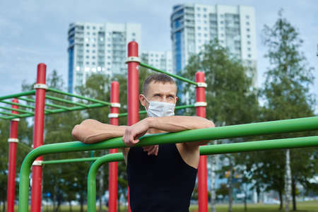 athletic man, in the morning in the city Park doing exercises with gymnastic ropes