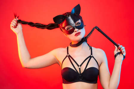 beautiful girl in a cat mask. playfully posing in front of the camera.の写真素材