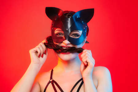 beautiful girl in a cat mask. playfully posing in front of the camera.の写真素材