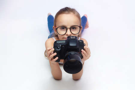 Little girl with glasses, holding a red Apple.の写真素材