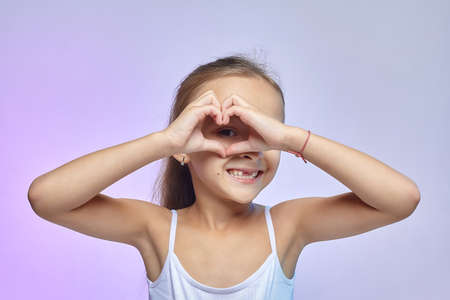 Little girl with glasses, holding a red Apple on her head.の写真素材