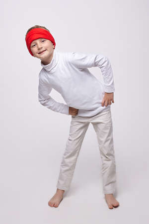 young boy in a headband in the studio on a white backgroundの写真素材