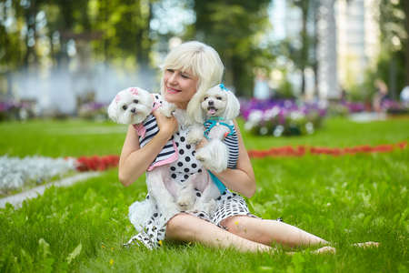 adult woman in the park with two Maltese lapdogs.の写真素材