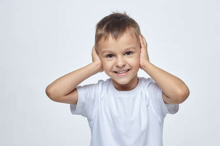 small boy with a smile holds a green Apple and points at it with his finger. photo session in the Studio on a white backgroundの写真素材