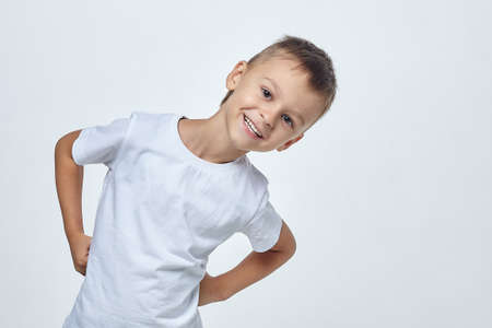 small boy with a smile holds a green Apple and points at it with his finger. photo session in the Studio on a white backgroundの写真素材