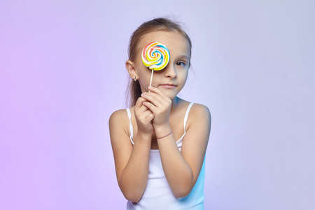 a little girl holds a large candy in her hands.の写真素材