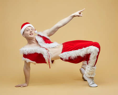 young guy in a Santa suit. photo session in the Studioの写真素材