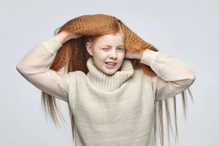 teen girl with long red hair in Studio on white backgroundの写真素材