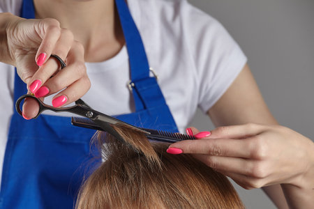 close-up hair cutting. the barber's hands hold the ends of the hairの写真素材