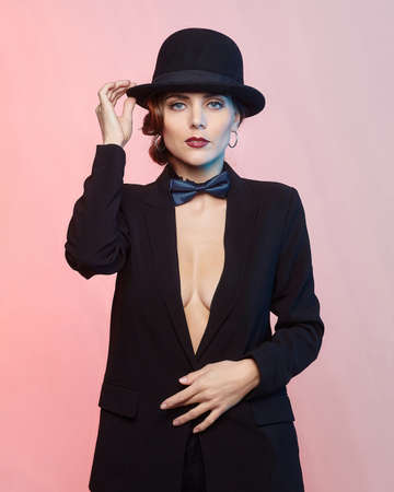 attractive young woman in a man's suit and a fedora. retro style photo shoot