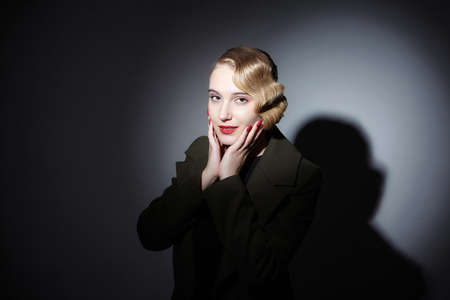 attractive blonde with a retro hairstyle in a black hat with a wide brim