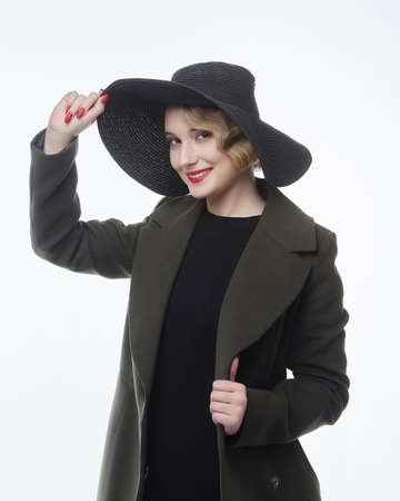 attractive blonde with a retro hairstyle in a black hat with a wide brimの写真素材