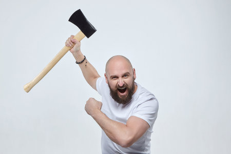 portrait of a man holding an ax near his cheek. photo shoot in the studio on a dark backgroundの写真素材