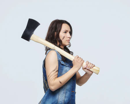 portrait of an attractive woman with an ax. in the studio on a white background