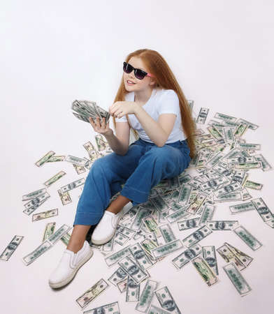 attractive red-haired girl holds 100 euro banknotes in her handsの写真素材
