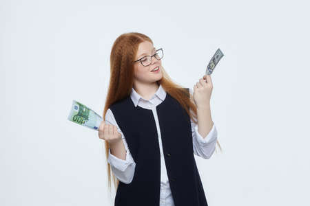 attractive red-haired girl holds 100 euro banknotes in her handsの写真素材