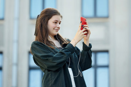 guy and a girl are holding burgers and drinks in their hands. the girl gives the guy a drink from her glass.の写真素材