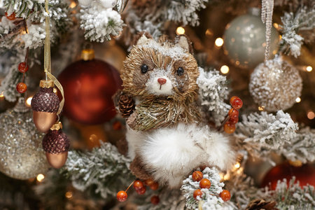 Christmas toys hanging on a winter Christmas tree covered with snow.の写真素材