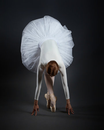 elegant ballerina posing in the studio on a dark background.の写真素材