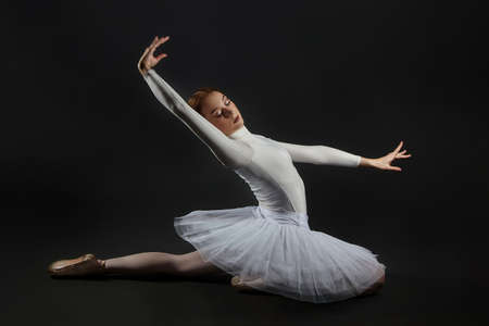 portrait of a ballerina holding pointe shoes. photo shoot in the studio on a dark background.の写真素材
