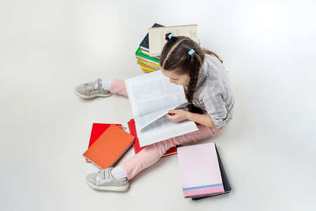 portrait of a little black-haired girl holding a red book in her hands.の写真素材