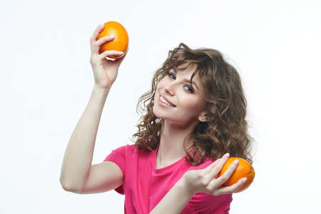 attractive girl with oranges in her hands photo shoot in the studio on a white background.の写真素材