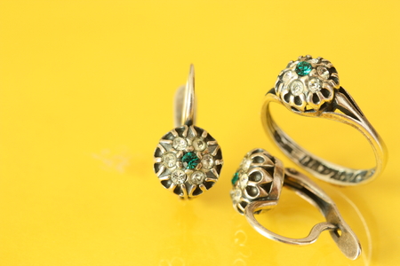 Women's earrings and ring on a yellow backgroundの写真素材