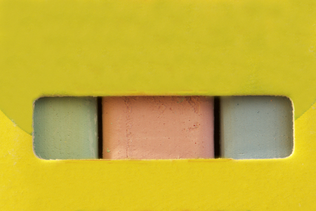 Chalk for drawing. Multi-colored chalk in paper box. Different colors can be seen through a horizontal slit in the package. Green red and blue.の写真素材