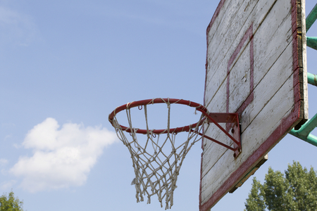 Basketball board with a net. Old, wooden planks. Painted. Located on a background of blue sky with...