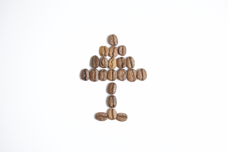 Roasted grains of black coffee. The grains are laid out in the form of a pyramid, the hands.の写真素材