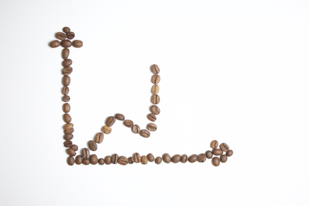 Roasted grains of black coffee. The grains are laid out in the form of axes and the rising graph.の写真素材