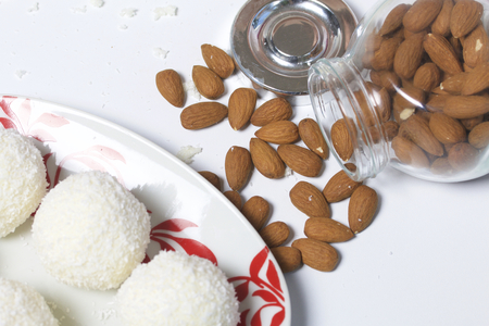 Preparation of Raffaello sweets at home. Ready-made sweets lie on a plate. On a background of a jar with scattered almonds.の写真素材