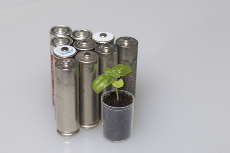 Batteries and green sprout. Recycling and disposal of batteries. Care for ecology.の写真素材