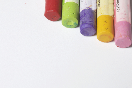 Colorful crayons pastels lie in a row. On a white background. View from above.の写真素材