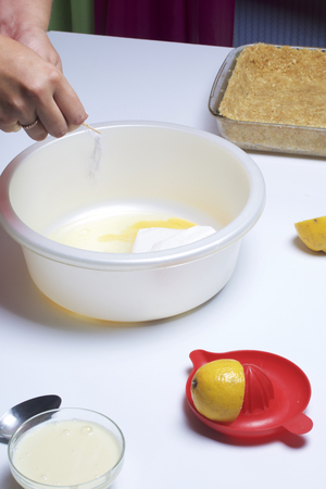 The woman adds vanillin to cottage cheese. Nearby there is a chopped cookie. Basis for the tender cheesecake.の写真素材