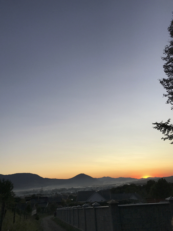 Sunset in the highlands. Soft sunrays illuminate the mountains on the horizon.の写真素材