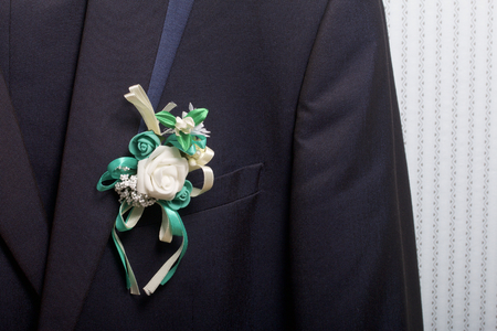 The bridegroom's suit hangs on a hanger. On the chest attached a wedding flower.の写真素材