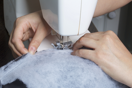 Sewing clothes by an individual entrepreneur. A woman is working on a sewing machine. Staples the...