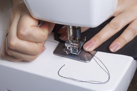 Sewing clothes by an individual entrepreneur. A woman is working on a sewing machine. Staples the...